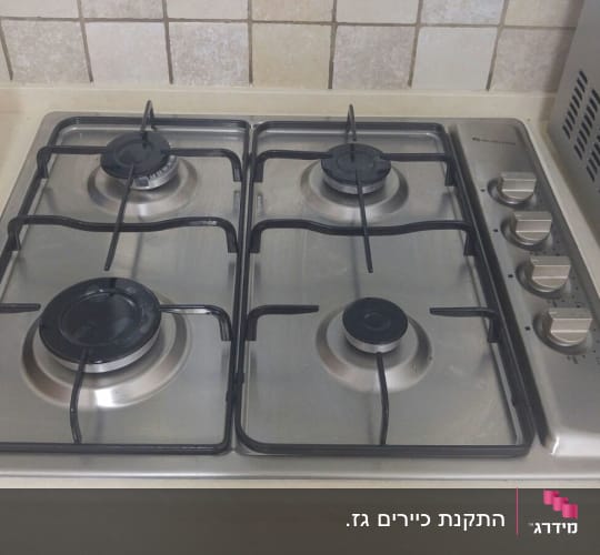 כיריים גז עם ארבעה מבערים וכפתורי שליטה
